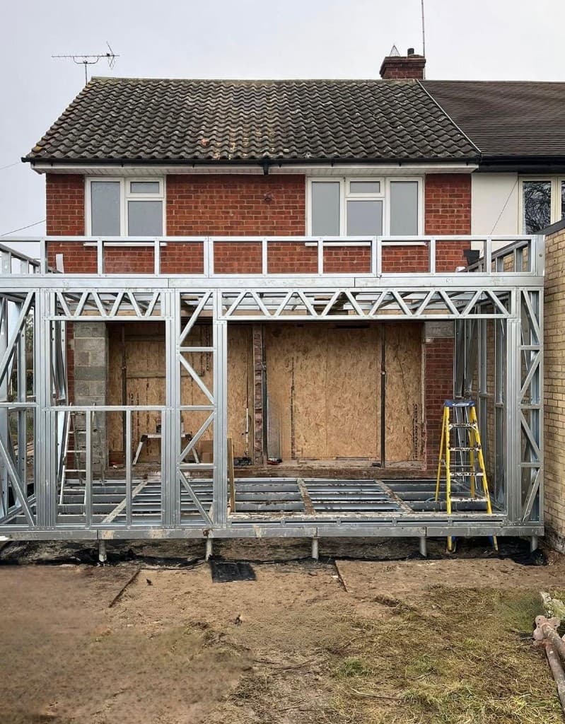 Construction team working on a brick home extension with scaffolding