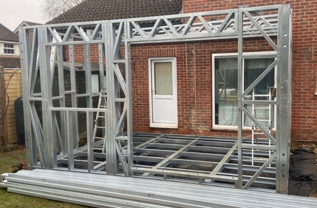 Two-storey steel frame extension with insulation boards being fitted